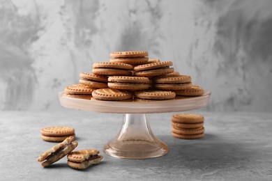Photo of Tasty sandwich cookies with cream on grey table