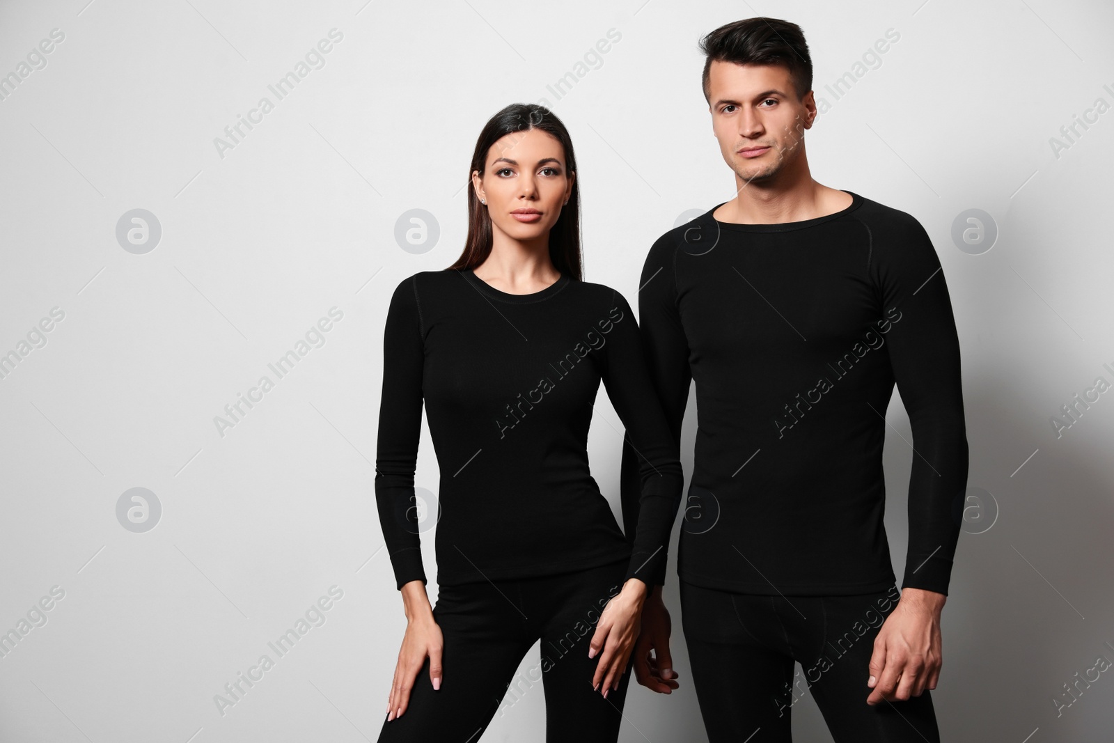 Photo of Couple wearing thermal underwear on light grey background. Space for text