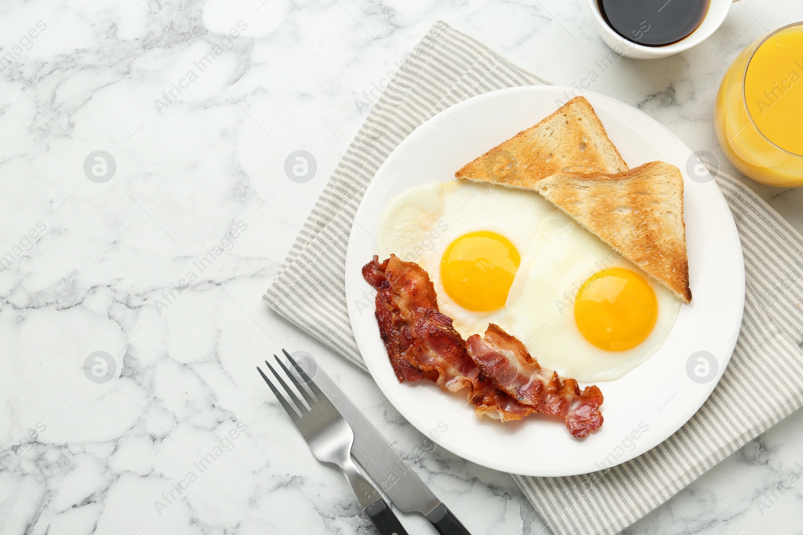 Photo of Delicious breakfast with sunny side up eggs served on white marble table, flat lay. Space for text