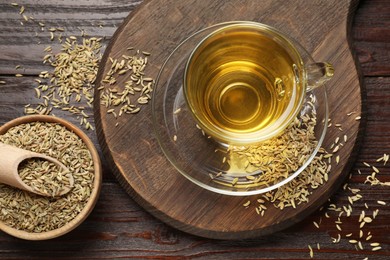 Photo of Aromatic fennel tea and seeds on wooden table, flat lay