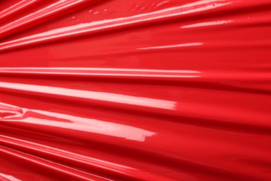 Photo of Red plastic stretch wrap as background, closeup