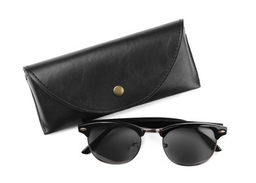 Photo of Modern sunglasses and black case on white background, top view