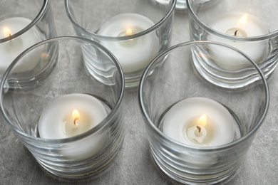 Photo of Beautiful burning wax candles in glasses on table