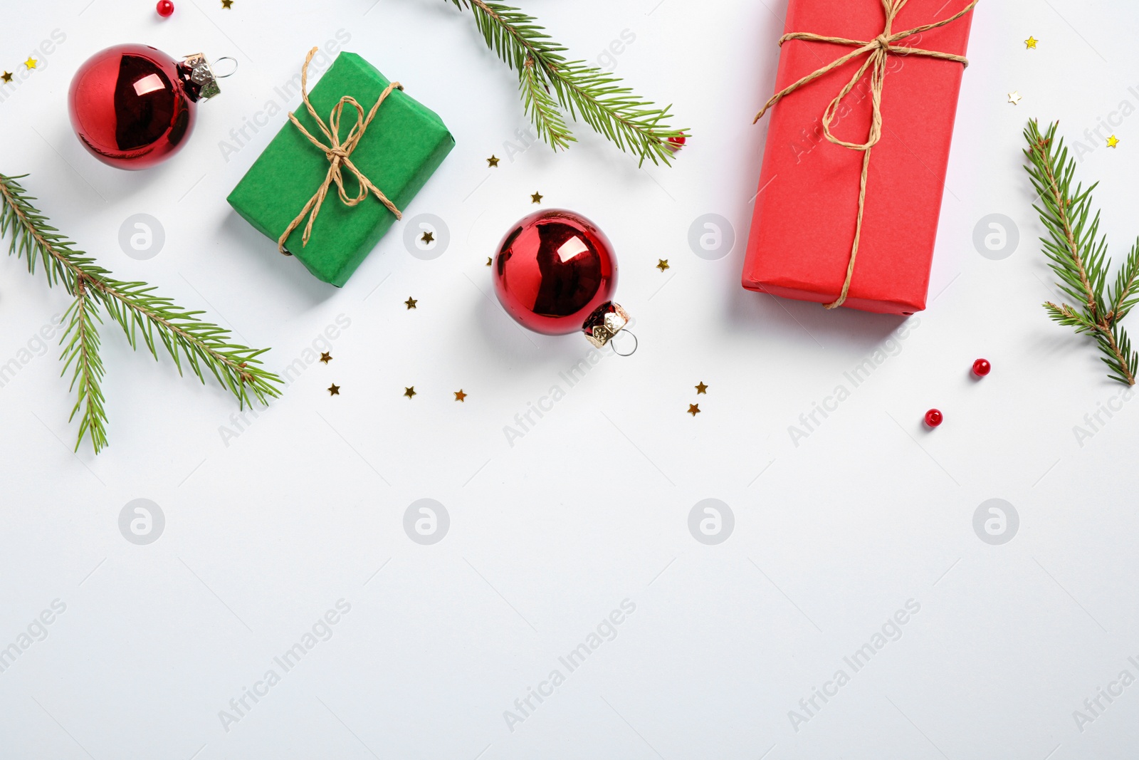 Photo of Flat lay composition with Christmas gifts and festive decor on white background. Space for text