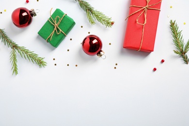 Flat lay composition with Christmas gifts and festive decor on white background. Space for text