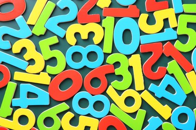 Photo of Colorful numbers on green background, top view