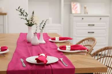 Photo of Beautiful table setting and vases with green branches in dining room