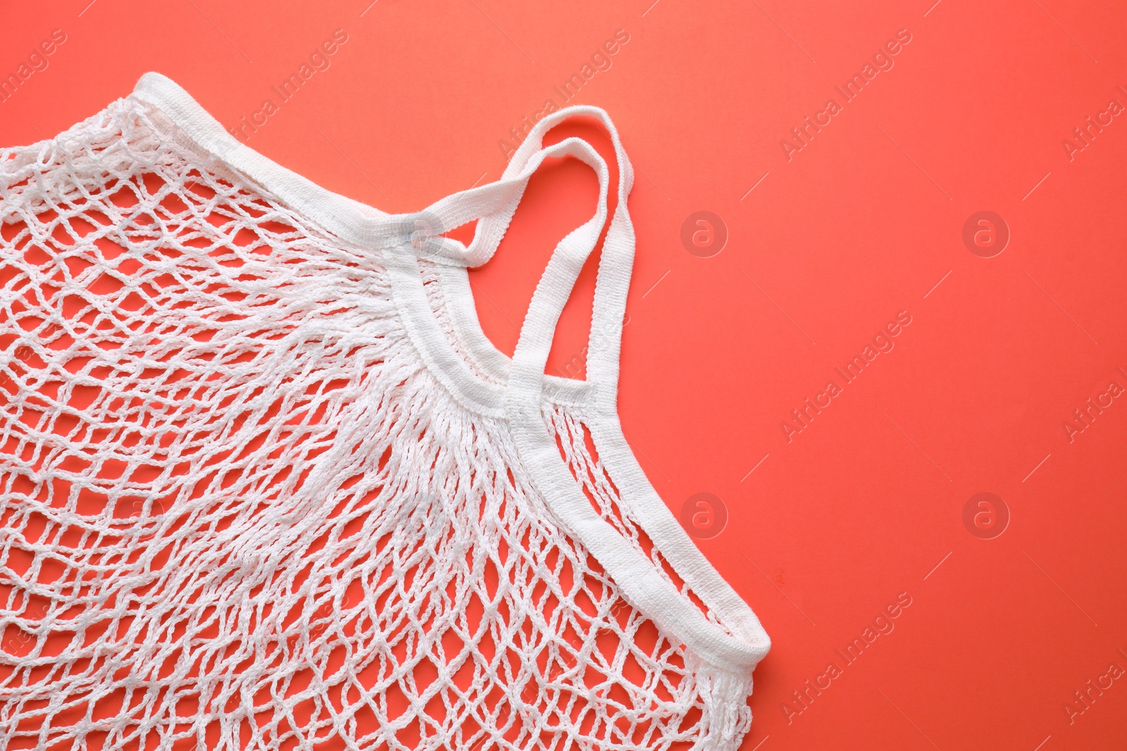 Photo of White string bag on red background, top view. Space for text