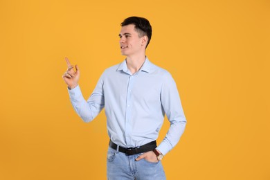 Photo of Portrait of handsome young man gesturing on yellow background