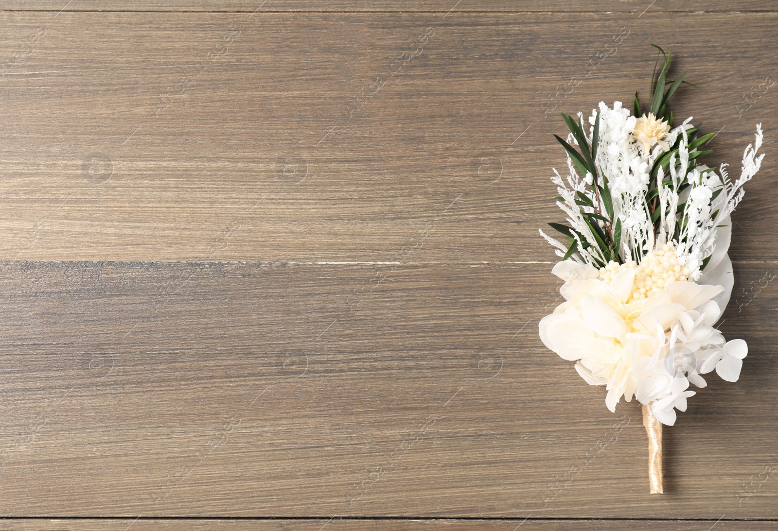 Photo of Beautiful boutonniere on wooden background, top view. Space for text