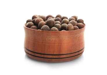 Photo of Wooden bowl with allspice pepper grains on white background