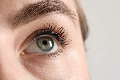 Macro photo of woman with beautiful eyes on light background