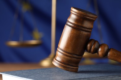 Photo of Wooden judge's gavel and book on table against European Union flag, closeup