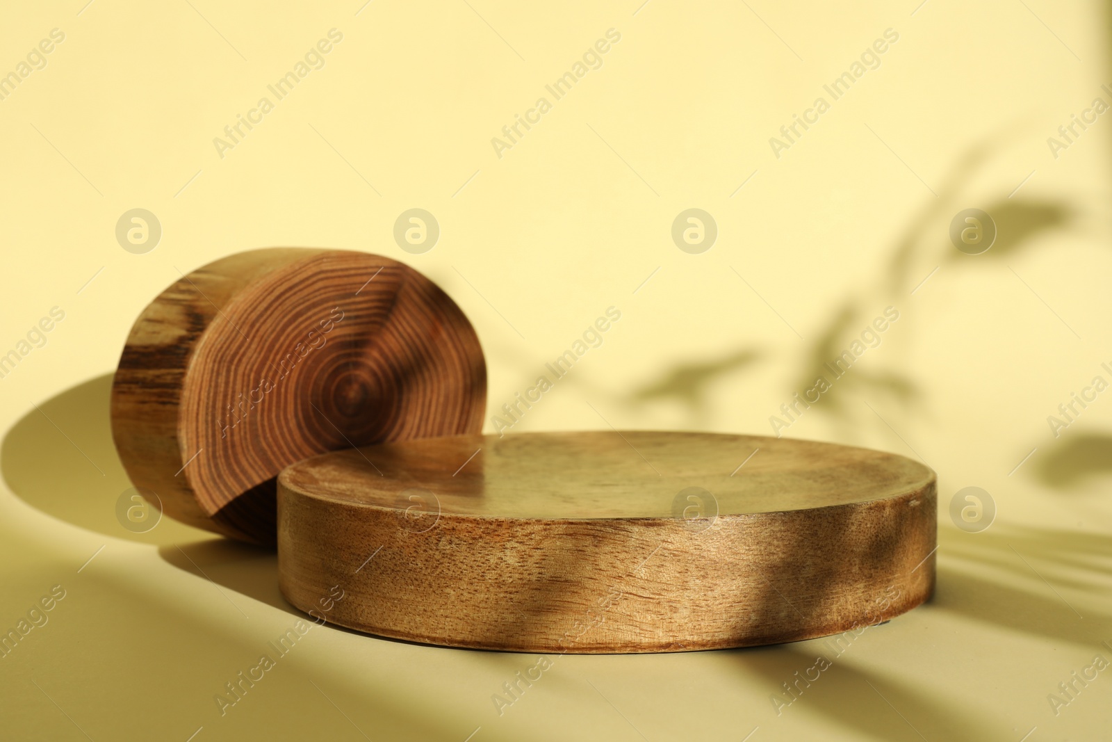 Photo of Presentation of product. Wooden podiums on yellow background. Space for text