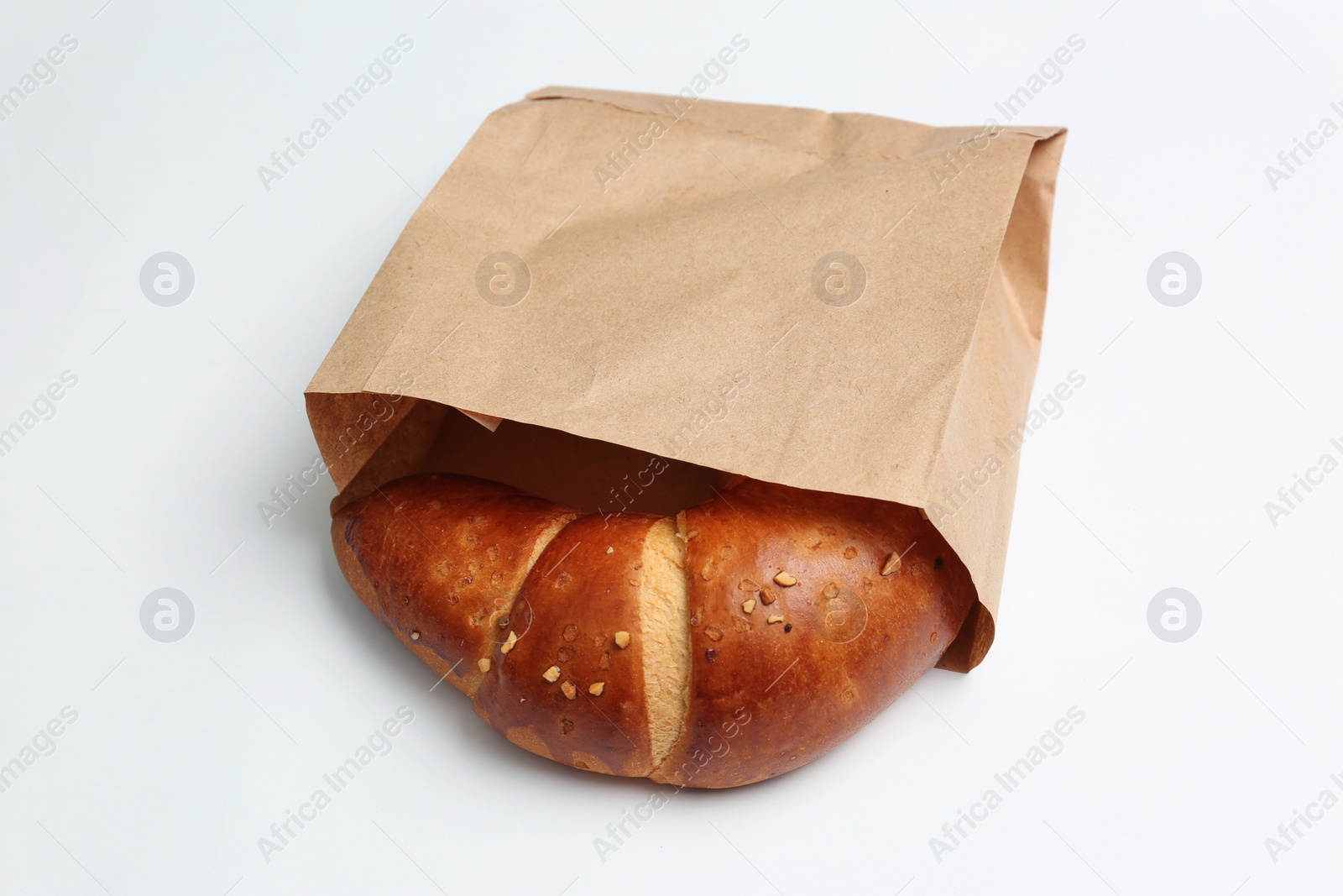 Photo of Paper bag with croissant on white background. Space for design