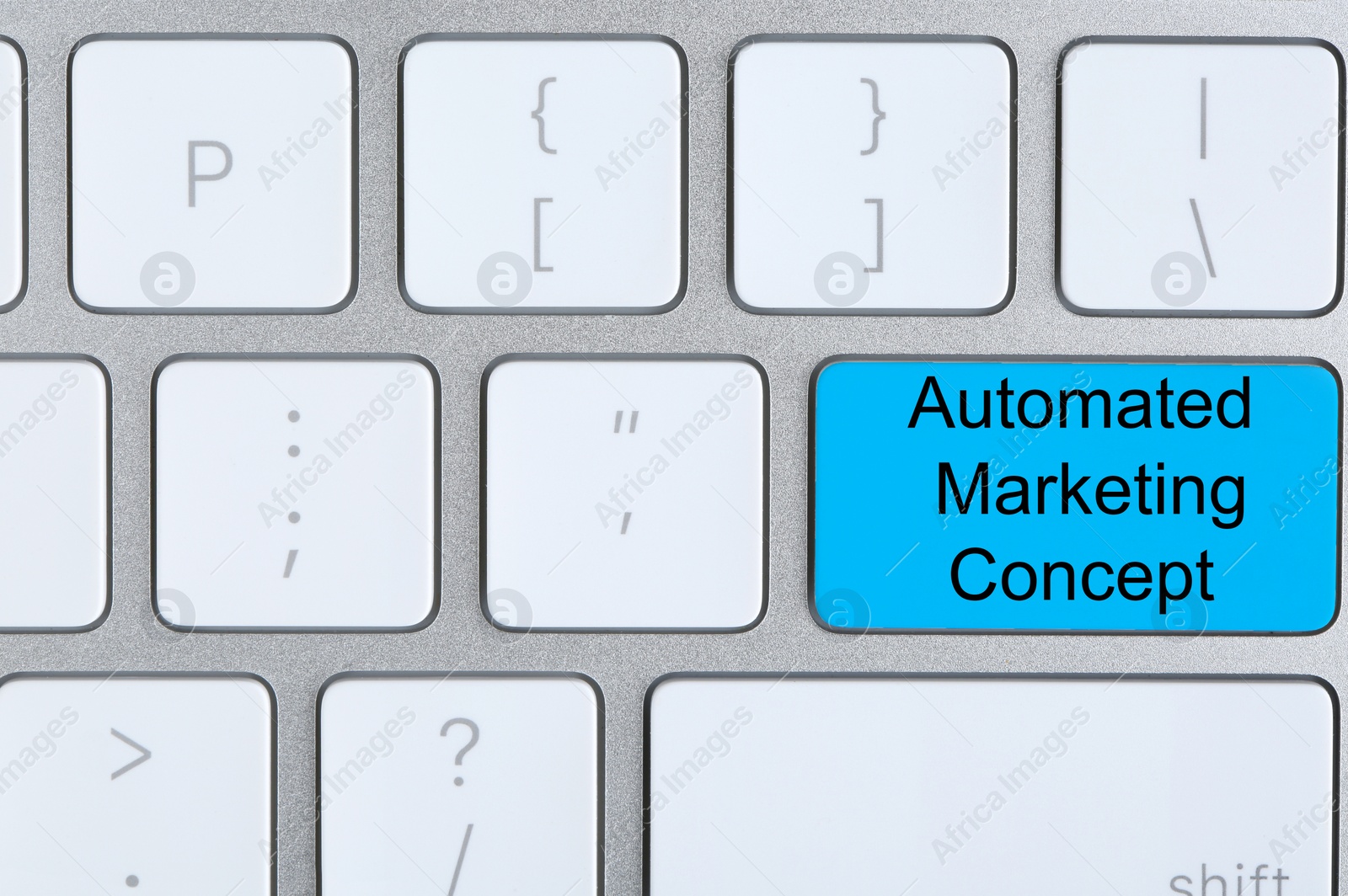 Image of Modern computer keyboard with text AUTOMATED MARKETING CONCEPT on button, top view