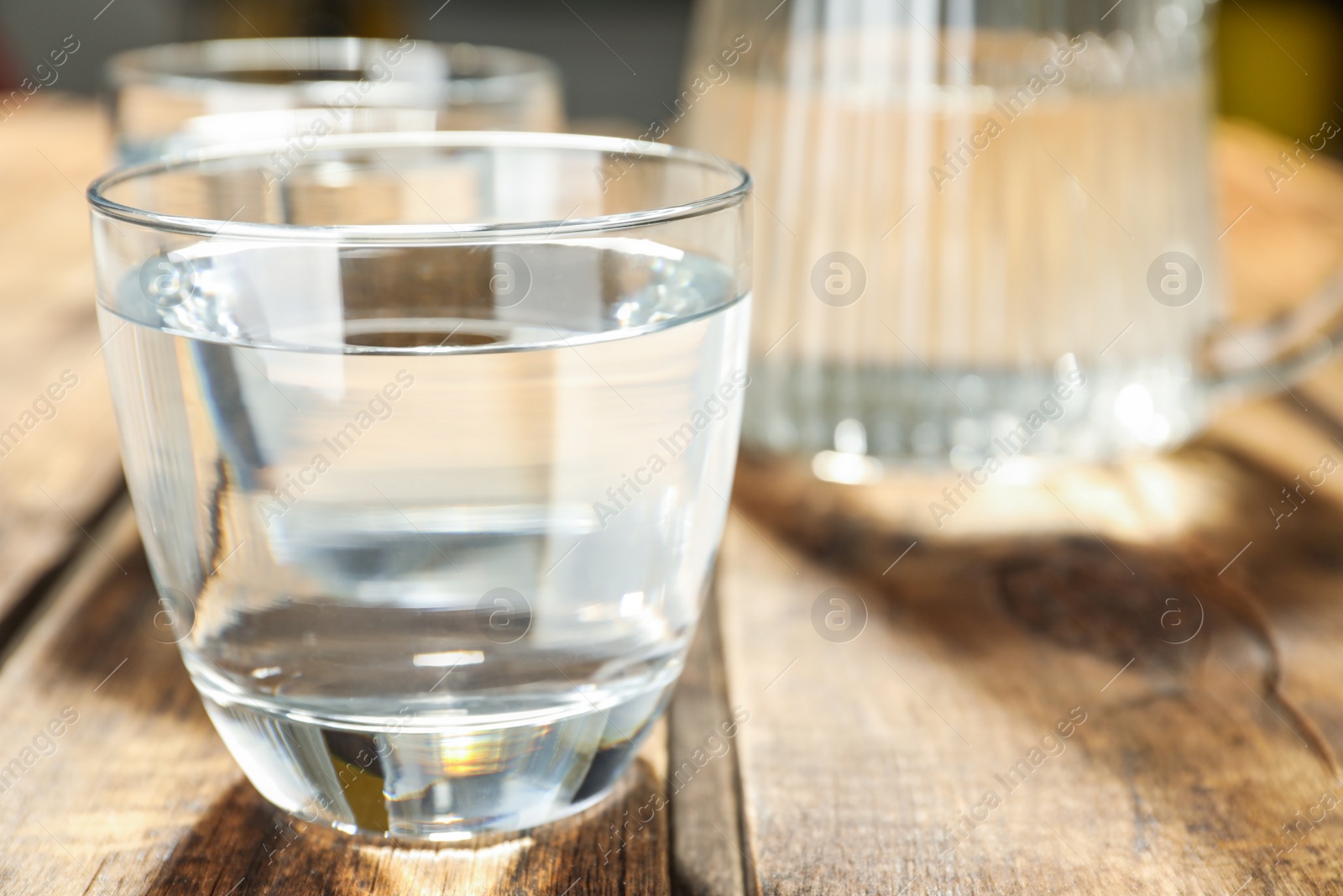 Photo of Glass of water on wooden table, closeup. Refreshing drink