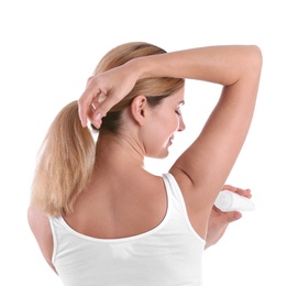 Young woman using deodorant on white background