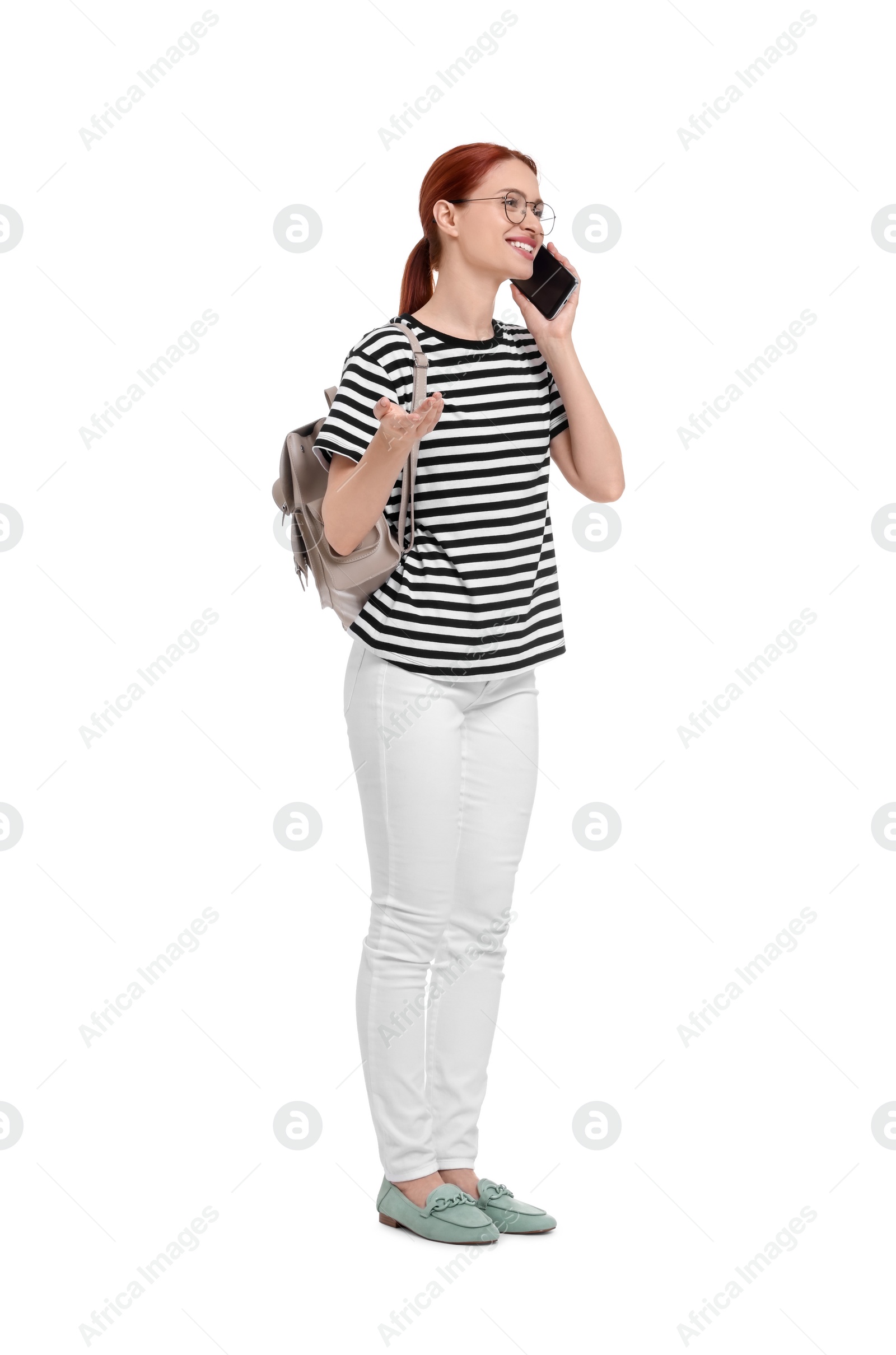 Photo of Happy woman with backpack talking on smartphone against white background