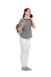 Happy woman with backpack talking on smartphone against white background