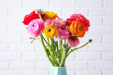 Beautiful fresh ranunculus flowers near white brick wall