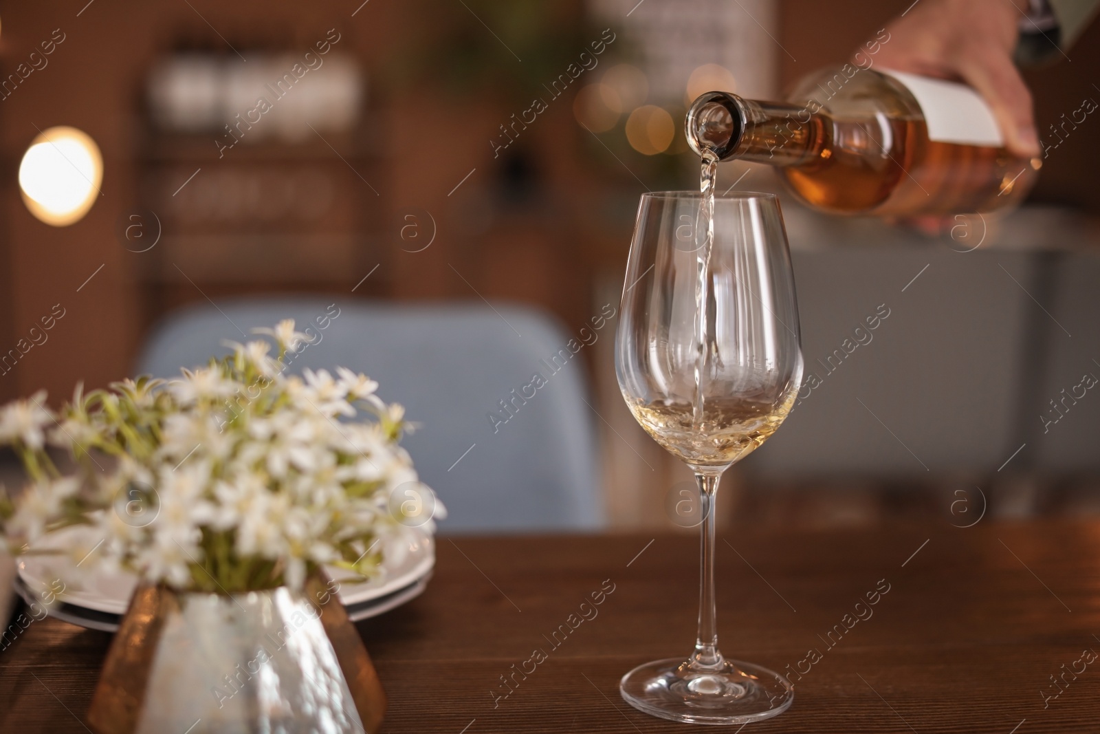 Photo of Man pouring wine into glass on table