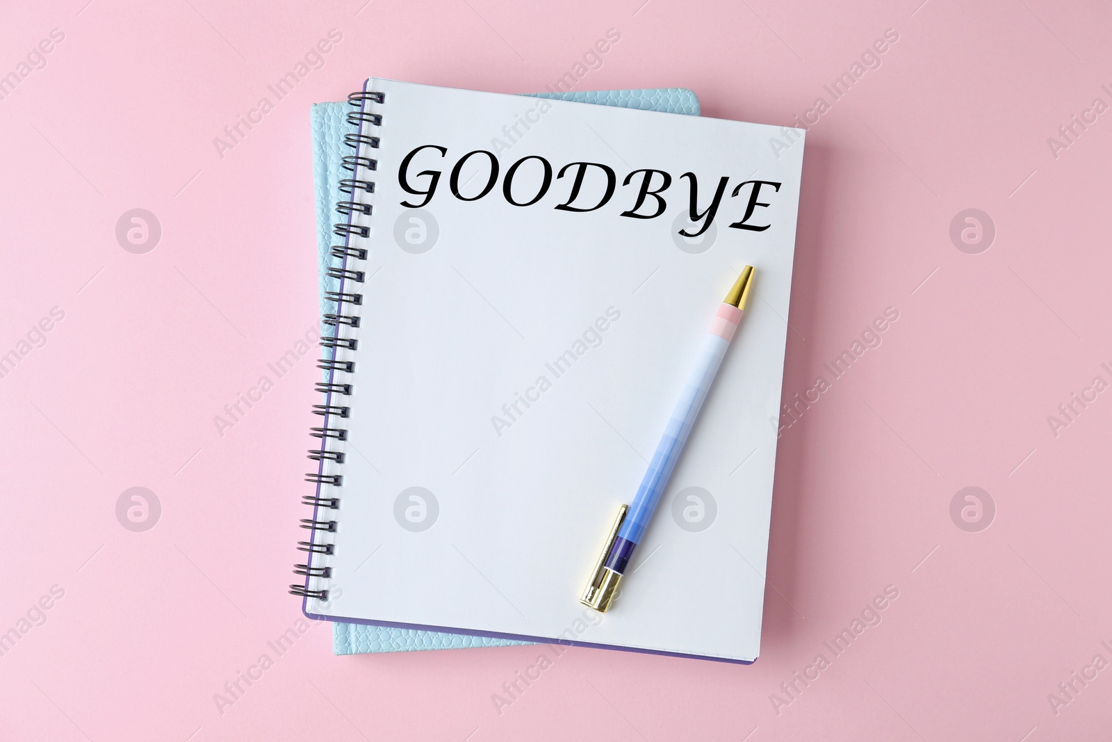 Image of Notebook with word Goodbye on pink background, top view