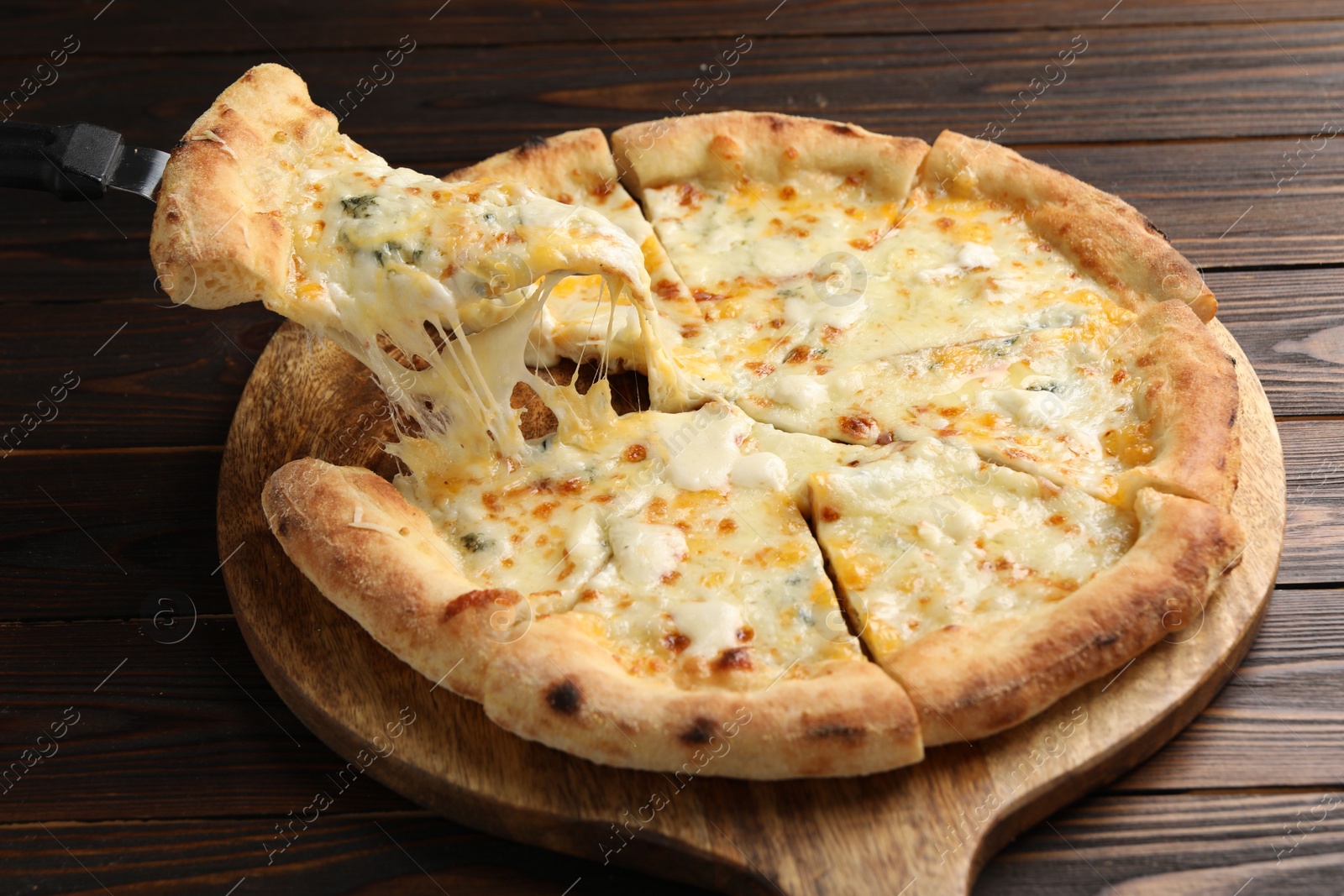 Photo of Taking piece of delicious cheese pizza at wooden table