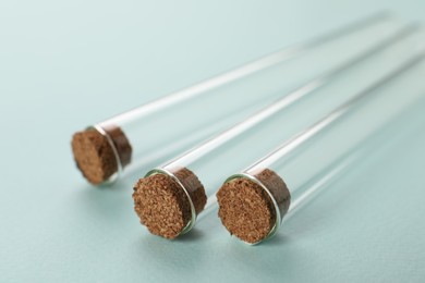 Photo of Test tubes on turquoise background, closeup. Laboratory glassware