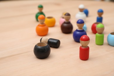 Photo of wooden colorful dolls shaped building blocks on table, closeup. Montessori toy