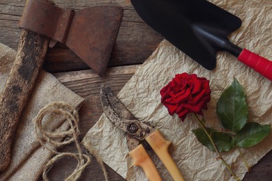 Photo of Flat lay composition with old secateurs and other gardening tools on wooden table
