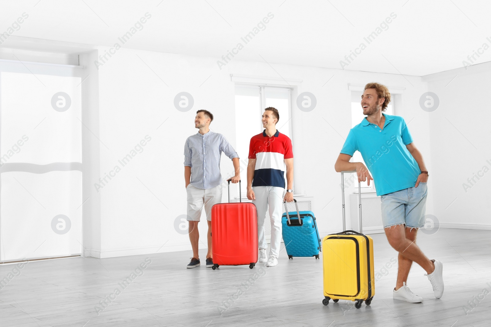 Photo of Group of young people with suitcases in light room