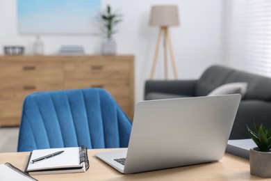 Photo of Home workspace. Laptop and stationery on wooden desk indoors