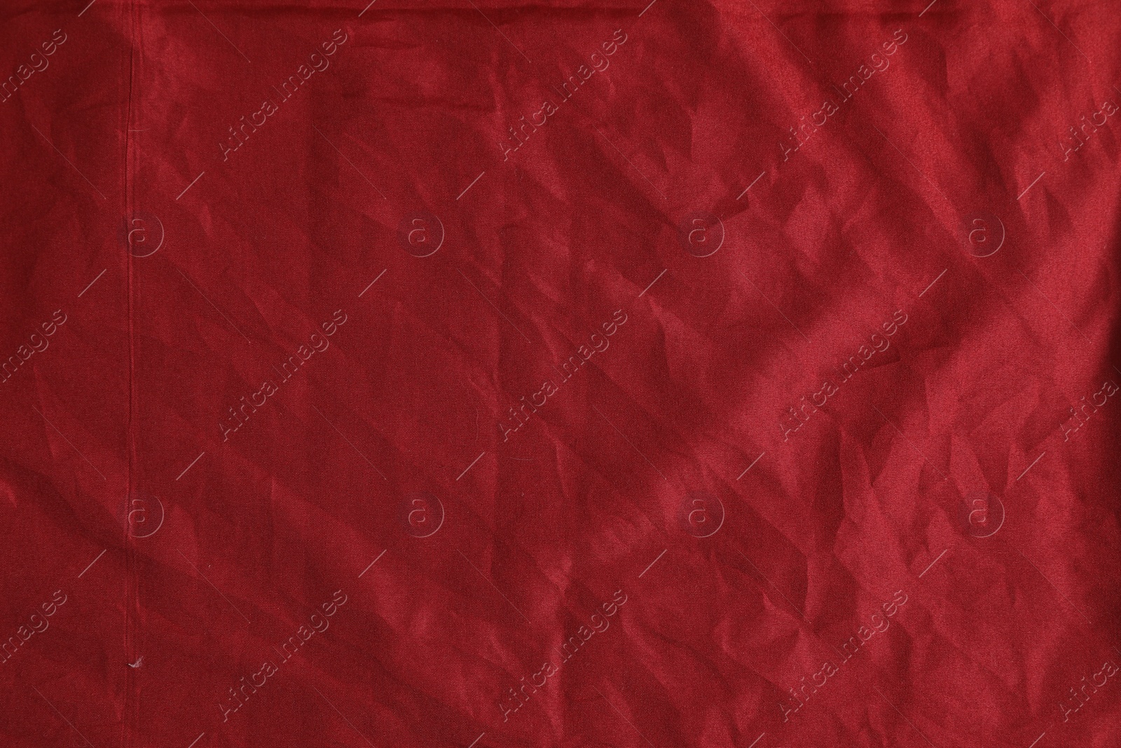 Photo of Crumpled dark red fabric as background, top view