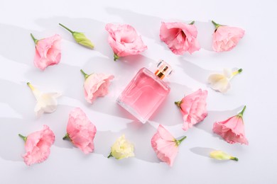Photo of Luxury perfume and floral decor on white background, flat lay