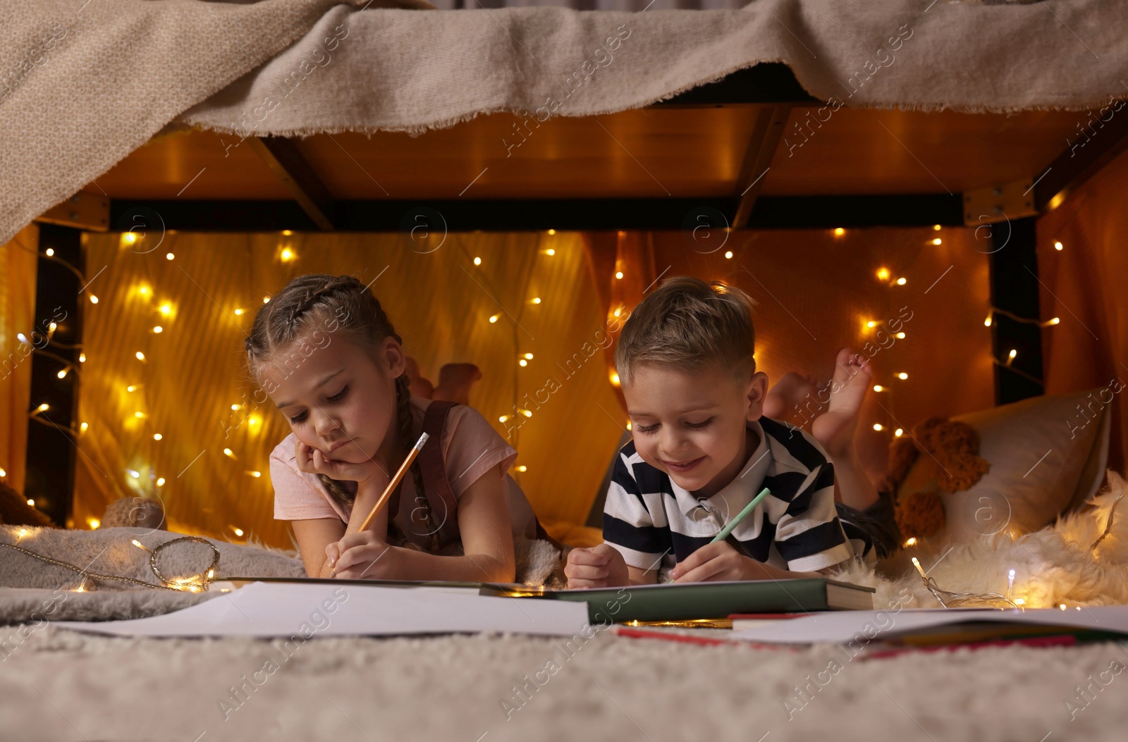 Photo of Children drawing in play tent at home