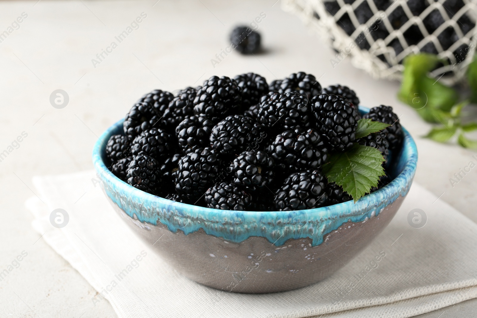 Photo of Tasty ripe blackberries in bowl on table