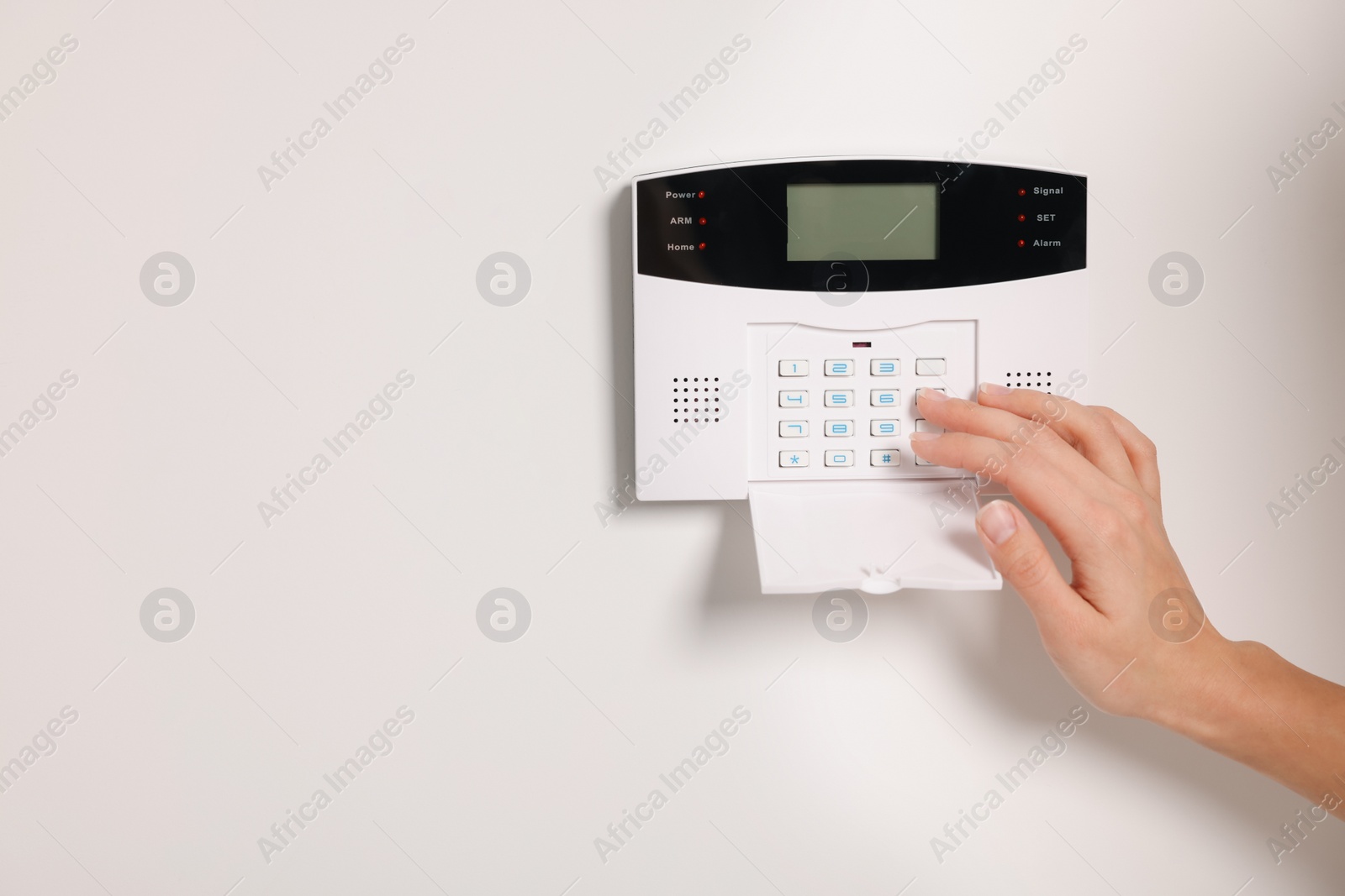 Photo of Woman entering code on home security system, closeup. Space for text