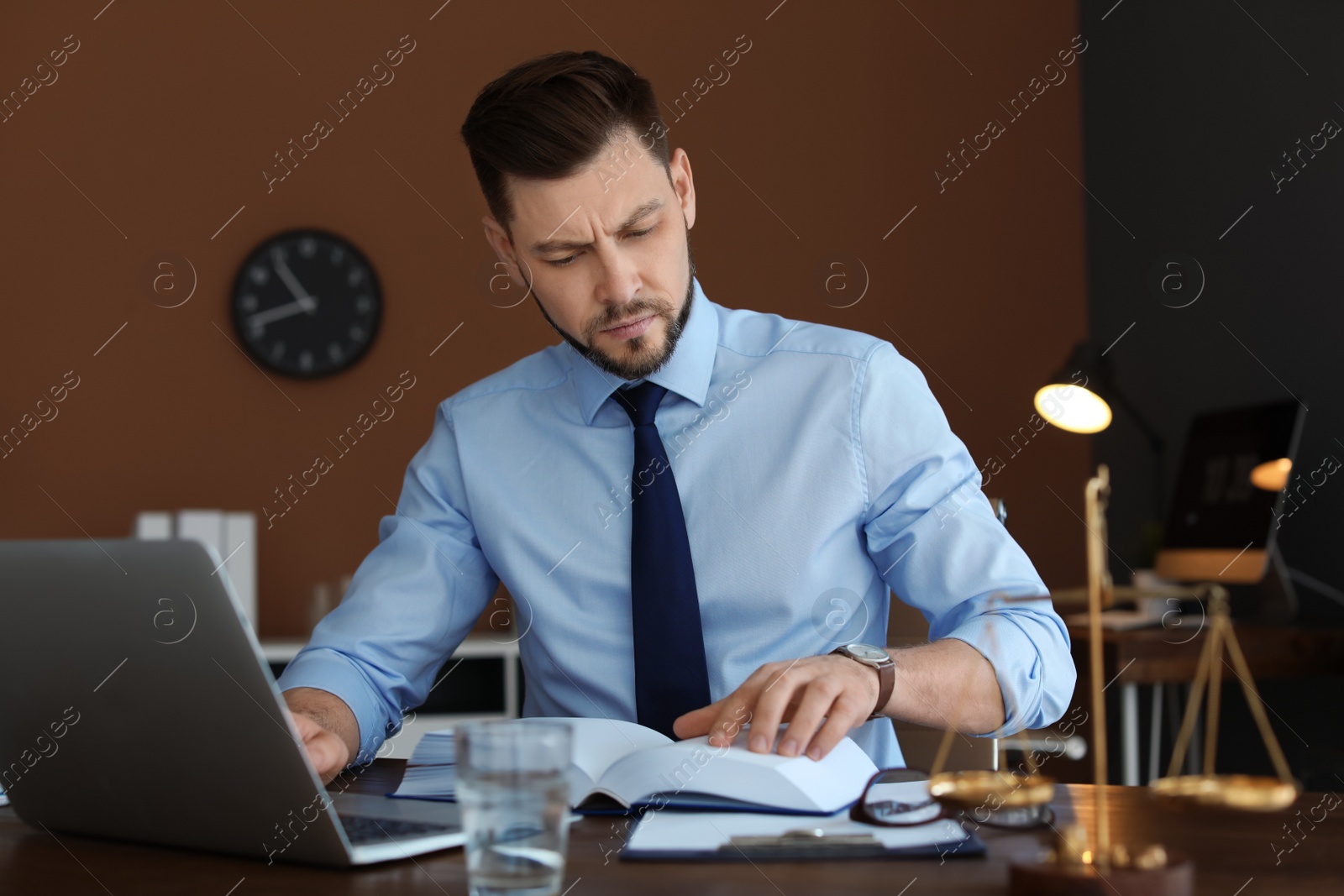 Photo of Male lawyer working with laptop in office