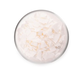 Photo of Wax flakes in glass bowl on white background, top view. Homemade candle material