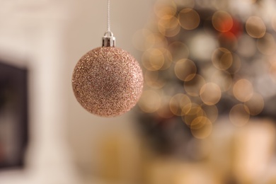 Photo of Beautiful Christmas bauble hanging against blurred background