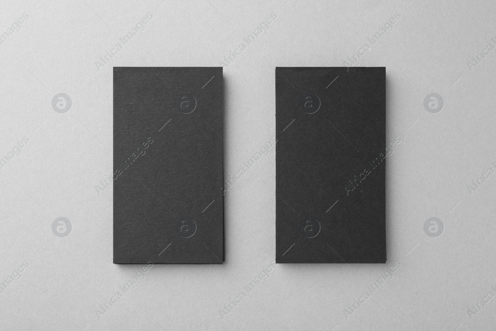 Photo of Blank black business cards on light background, top view. Mockup for design