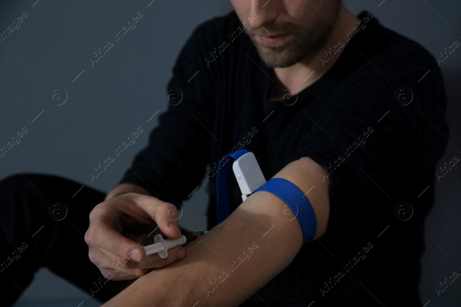 Photo of Male drug addict making injection, focus on hands