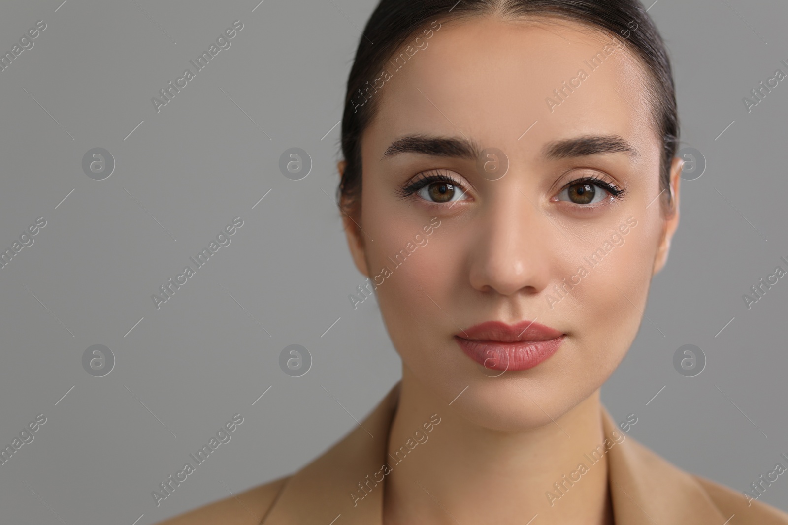 Photo of Portrait of beautiful young woman on grey background, closeup. Space for text