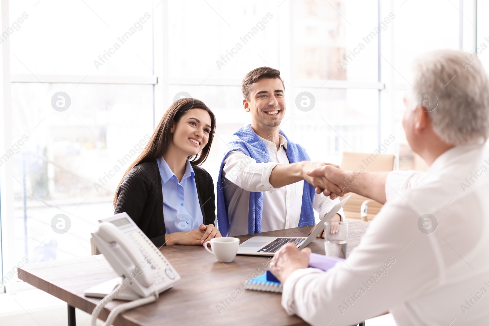 Photo of Human resources manager shaking hands with applicant during job interview in office