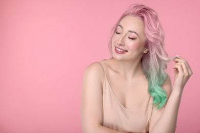 Image of Trendy hairstyle. Young woman with colorful dyed hair on pink background. Space for text