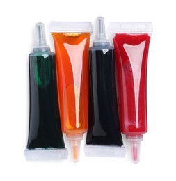 Tubes with different food coloring on white background, top view