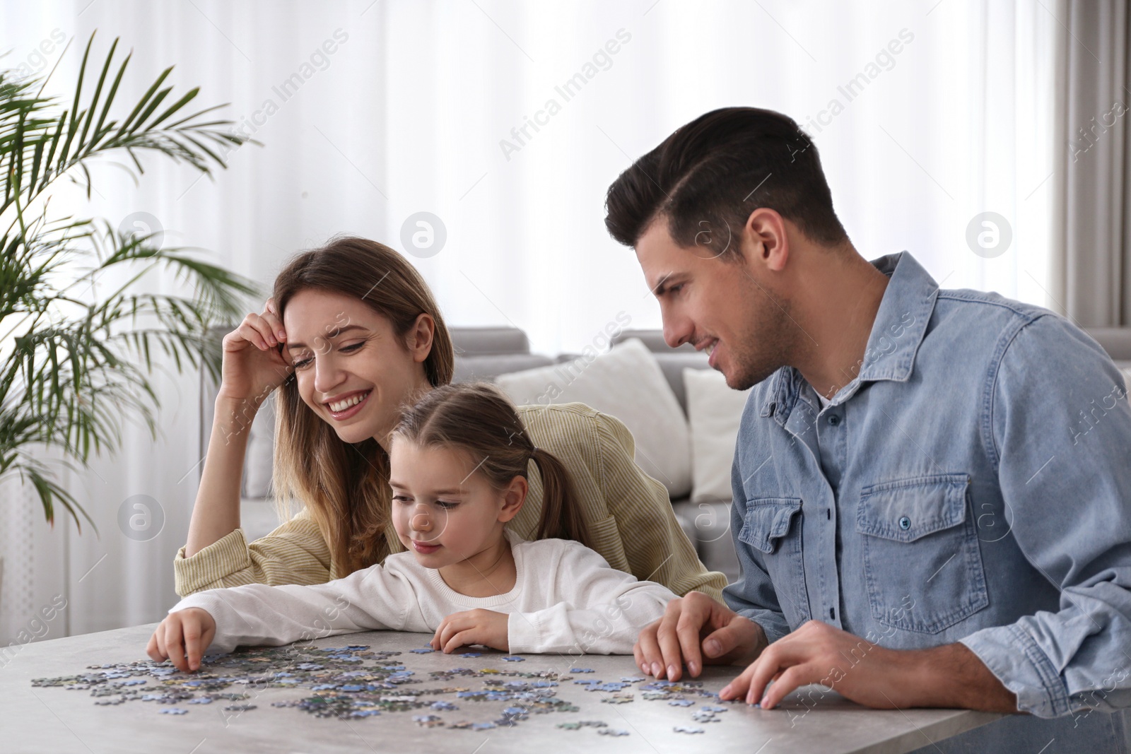 Photo of Happy family playing with puzzles at home