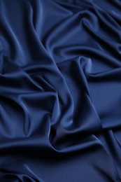 Photo of Crumpled dark blue silk fabric as background