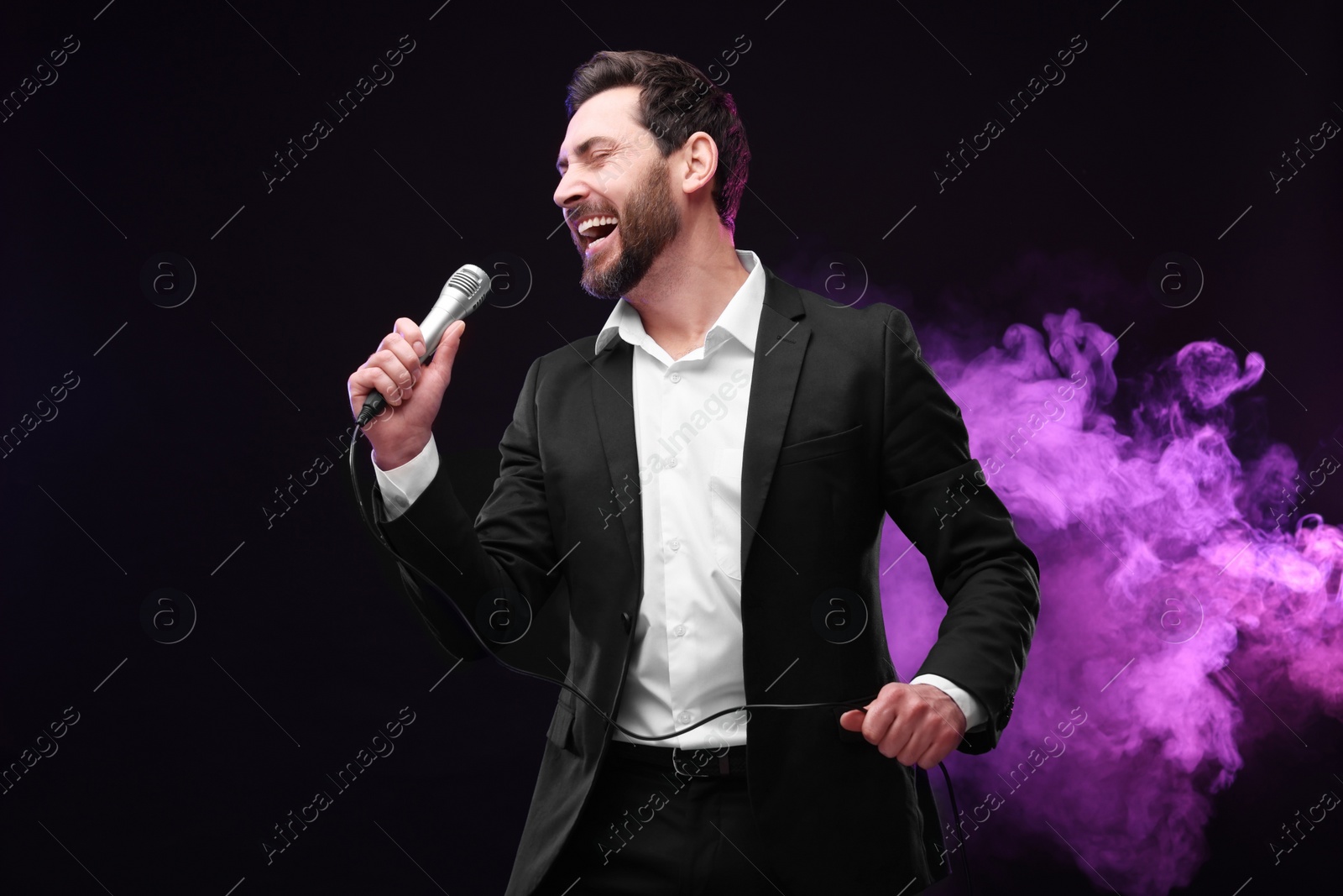 Photo of Emotional man with microphone singing in neon lights